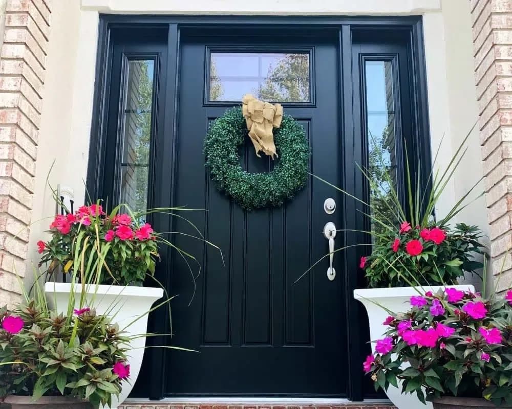 Black entry door with glass sidelights and a silver handle