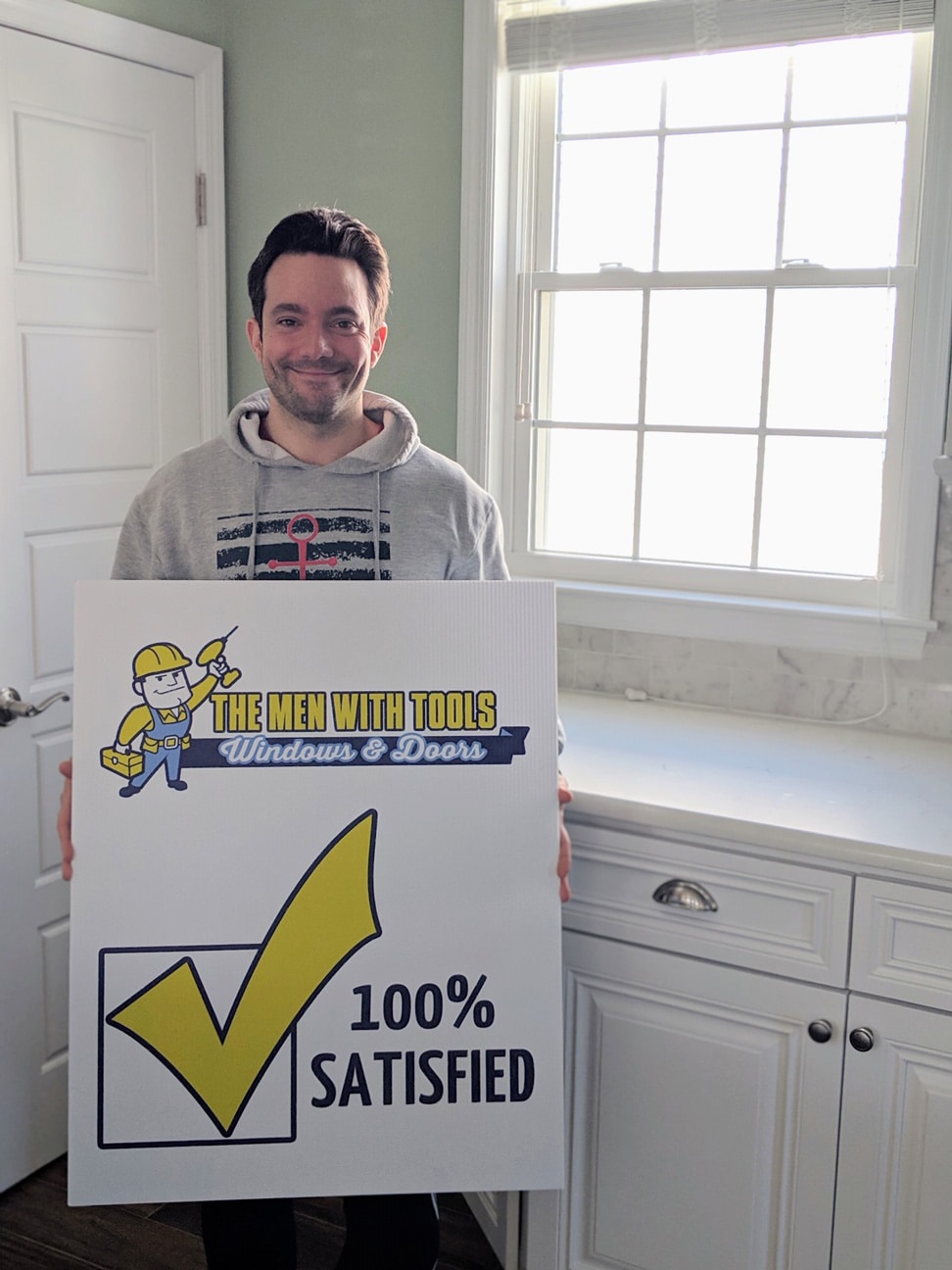 A customer holding a 100% satisfied sign